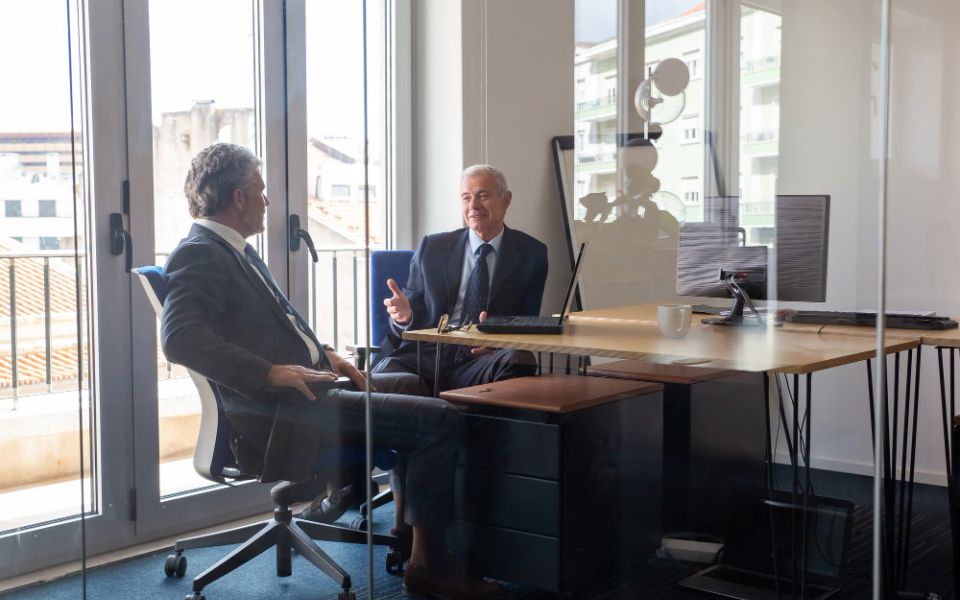 two men talk in office